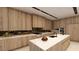 Modern kitchen with sleek wooden cabinetry, a marble island, and high-end appliances for culinary enthusiasts at 607 Grand Rim Dr, Henderson, NV 89012