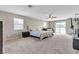 Spacious bedroom featuring plush carpet, ceiling fan, and sliding glass doors to a balcony at 6116 Camas Canyon Ave, Las Vegas, NV 89130