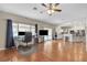Bright living room with hardwood floors, a ceiling fan, and a large window overlooking the back patio at 6116 Camas Canyon Ave, Las Vegas, NV 89130