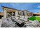 Spacious outdoor area with stylish patio furniture, a well-manicured lawn, and a modern outdoor grill at 6544 Sandero Springs St, Las Vegas, NV 89166