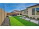 Lush artificial grass and modern stone pathways create a serene backyard retreat with a spacious patio area at 6544 Sandero Springs St, Las Vegas, NV 89166