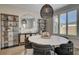 Bright dining area with a modern light fixture, large round mirror, and decorative shelving units at 6544 Sandero Springs St, Las Vegas, NV 89166