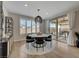 Modern dining area with a round table, contemporary light fixture, and sliding glass doors leading to the backyard patio at 6544 Sandero Springs St, Las Vegas, NV 89166