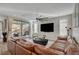 Spacious living room featuring a large leather couch, big-screen TV, and access to the outdoor patio at 6544 Sandero Springs St, Las Vegas, NV 89166