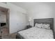 Well-lit bedroom featuring a bed, side table, closet with sliding doors, and an open doorway to another room at 713 Webber Park St, Henderson, NV 89011