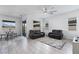 Bright living room features tile floors, large windows, modern ceiling fan, and comfortable seating at 713 Webber Park St, Henderson, NV 89011
