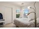 Well-lit bedroom features two windows, sliding closet doors, and unique lamp at 7572 Hope Valley St, Las Vegas, NV 89139