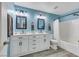 Stylish bathroom featuring dual vanities, modern lighting, and a shower-tub combination at 781 Wigan Pier Dr, Henderson, NV 89002