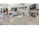 Open Gathering room with stone fireplace, light gray sofa, and view to game room at 781 Wigan Pier Dr, Henderson, NV 89002