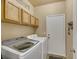 Well-lit laundry room featuring a Samsung washer and dryer, cabinets, and a convenient storage basket at 781 Wigan Pier Dr, Henderson, NV 89002