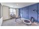 Exercise room with navy accent wall, large window, and fitness equipment including weights and trampoline at 7920 Pandora Sky St # 281, North Las Vegas, NV 89084