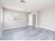 Spacious bedroom with a large window, neutral walls, and stylish gray wood-look flooring at 8174 Amphora St, Las Vegas, NV 89139