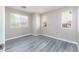 Bright bedroom with a large window, neutral walls, and stylish gray wood-look flooring at 8174 Amphora St, Las Vegas, NV 89139