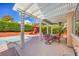 Relaxing covered patio with outdoor furniture, overlooking the pool and lush backyard at 8308 Tide Pool Dr, Las Vegas, NV 89128