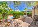 Charming backyard with lush greenery, covered patio, and inviting pool area at 8308 Tide Pool Dr, Las Vegas, NV 89128