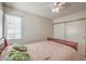 Bright bedroom features a ceiling fan, slider closet, and window with natural light at 8308 Tide Pool Dr, Las Vegas, NV 89128