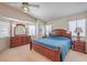 Bright bedroom featuring a wooden bed frame, a large dresser with mirror, and natural light from multiple windows at 8308 Tide Pool Dr, Las Vegas, NV 89128