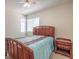Cozy bedroom with a wooden bed frame, a side table, and natural light filtering through the window at 8308 Tide Pool Dr, Las Vegas, NV 89128