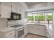 Bright kitchen features white cabinets, stainless steel appliances, and a window overlooking the backyard at 8308 Tide Pool Dr, Las Vegas, NV 89128