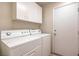 Well-lit laundry room featuring a washer, dryer, and upper cabinets at 8308 Tide Pool Dr, Las Vegas, NV 89128