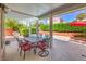 Covered patio with dining set overlooks a pool and landscaped backyard at 8308 Tide Pool Dr, Las Vegas, NV 89128