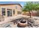 The backyard has a fire pit, patio, and tree providing shade at 8345 Spruce Meadows Ave, Las Vegas, NV 89131