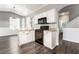 Kitchen featuring white cabinets, granite countertops, black appliances, and wood-look flooring, perfect for cooking at 8345 Spruce Meadows Ave, Las Vegas, NV 89131
