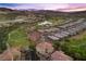 Wide aerial shot of a housing community with a golf course, lake, and mountain range in the background at 85 Luce Del Sole # 2, Henderson, NV 89011
