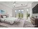 Bright bedroom with a ceiling fan, ensuite bath, and doors leading to the outdoor spaces at 85 Luce Del Sole # 2, Henderson, NV 89011