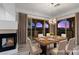 Staged dining room with a fireplace, stylish chandelier, and balcony access with scenic views at 85 Luce Del Sole # 2, Henderson, NV 89011