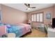 bedroom featuring a ceiling fan, a bed with colorful sheets and a shuttered window at 8924 Sail Bay Dr, Las Vegas, NV 89117