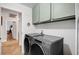 Laundry room with modern appliances and green cabinets, plus herringbone floors at 8924 Sail Bay Dr, Las Vegas, NV 89117