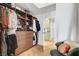 Spacious walk-in closet with custom wood shelving, drawers and herringbone floors plus a sitting chair with pillows at 8924 Sail Bay Dr, Las Vegas, NV 89117