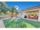 This backyard boasts a covered patio, artificial grass, mature landscaping, and BBQ area at 8962 Shale Valley St, Las Vegas, NV 89123