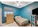 This bedroom features teal walls, wood floors, and a ceiling fan at 8962 Shale Valley St, Las Vegas, NV 89123