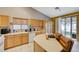 Well-lit kitchen with tan cabinets, white appliances, and a small island with bar seating at 8962 Shale Valley St, Las Vegas, NV 89123