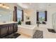 Bright bathroom features a soaking tub, dual vanities, and large windows for natural light at 9020 Tiffany Oaks Ave, Las Vegas, NV 89148