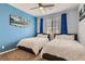 Comfortable bedroom with two beds, blue accent wall, a ceiling fan, and ample natural light at 9020 Tiffany Oaks Ave, Las Vegas, NV 89148