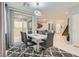 Elegant dining area with a modern table, six chairs, contemporary lighting, and backyard access at 9020 Tiffany Oaks Ave, Las Vegas, NV 89148