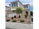 Two-story home featuring desert landscaping, muted exterior color scheme, attached two car garage, and blue shuttered windows at 9020 Tiffany Oaks Ave, Las Vegas, NV 89148