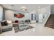 Inviting living room featuring a sectional sofa, modern decor, and a staircase leading upstairs at 9020 Tiffany Oaks Ave, Las Vegas, NV 89148