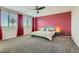 Inviting main bedroom featuring a large window, plush carpet, and neutral decor with red accent wall at 9020 Tiffany Oaks Ave, Las Vegas, NV 89148