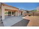 Backyard with patio, desert landscaping, and mature trees, enclosed by a brick wall at 9912 Woodhouse Dr, Las Vegas, NV 89134