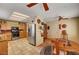 Traditional kitchen with stainless steel refrigerator, oak cabinets, tile floors and copper accents at 9912 Woodhouse Dr, Las Vegas, NV 89134