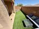 Inviting backyard boasts artificial grass, covered patio, and outdoor seating area at 10271 Headrick Dr, Las Vegas, NV 89166