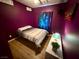 Purple bedroom featuring a comfortable bed, galaxy curtains, and light wood-look floors at 10271 Headrick Dr, Las Vegas, NV 89166