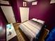 Beautiful purple bedroom featuring a comfortable bed, wood-look floors, and natural light at 10271 Headrick Dr, Las Vegas, NV 89166