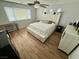 A bright primary bedroom with a large bed, light wood floors and a ceiling fan at 10271 Headrick Dr, Las Vegas, NV 89166