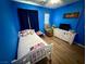 A bedroom with a white bed, blue walls and wood-look floors at 10271 Headrick Dr, Las Vegas, NV 89166