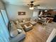 Bright living room with a large sectional couch, plank flooring, and views into the kitchen and dining area at 10271 Headrick Dr, Las Vegas, NV 89166